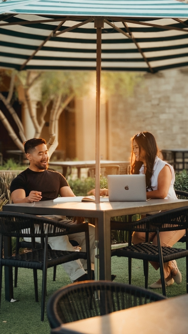 Leia and Jay working together at an outdoor café table